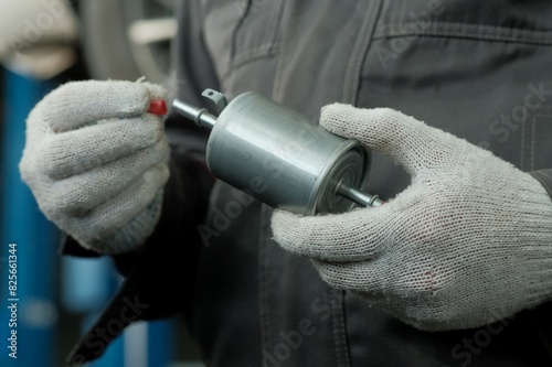 Auto parts.The fuel filter is new. Close-up.An auto mechanic prepares the fuel filter for replacement.Quality control of the spare part.