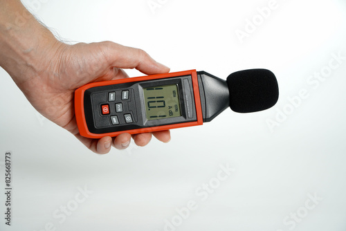 Pollution is too loud.hand holding a digital sound level on a white background,Sound level meters are commonly used in noise pollution studies.
