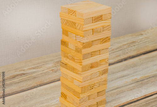 A tall, neatly stacked tower of wooden blocks on a wooden tabletop. Generic version of popular game.
