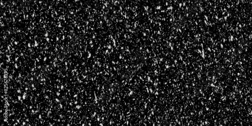 Snowflakes falling on black background. Winter weather. close up on paper with glitter. a black and white background with white dots.  Distressed uneven background.