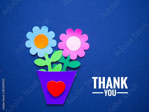Paper flower in a pot and a red heart shape with a thank you message on a blue background. Ideas for positive, gratitude, greeting card, apprecia, congratulation, banner, feedback, support, thank you.