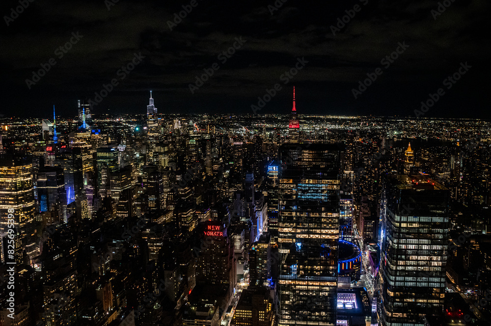 Naklejka premium Witness the awe-inspiring sprawl of Manhattan's skyscrapers from a daring perspective below. Towering giants pierce the clouds, offering a unique vantage point for travel and architecture content.