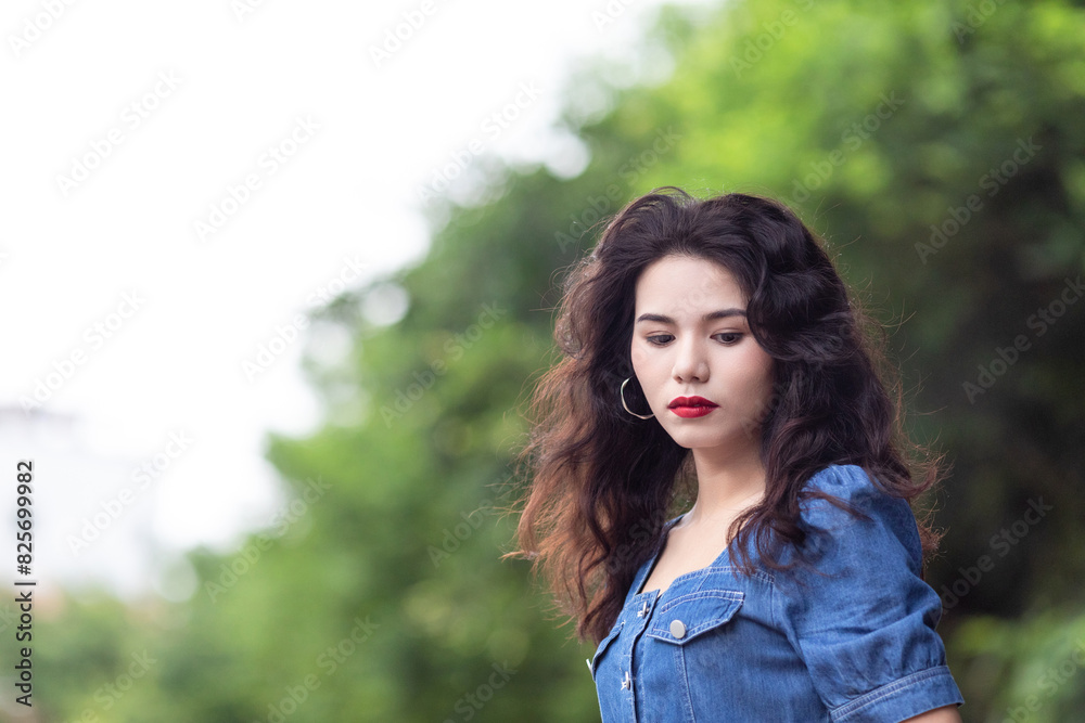 Outdoors a curly-haired Chinese beauty in a denim skirt Outdoors a curly-haired Chinese beauty in a denim skirt