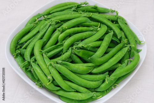 Green peas in a plate. Fresh peas in bowl. Bowls of vegetables.