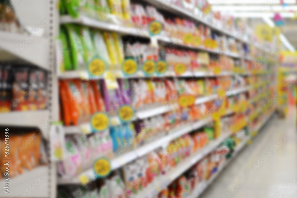 A woman shopping with a cart in a supermarket aisle full of groceries blur lens camera