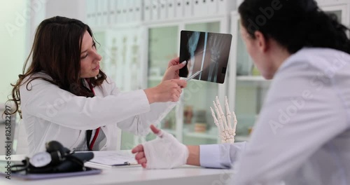 Doctor and patient discuss results of x-ray and fracture of hand photo