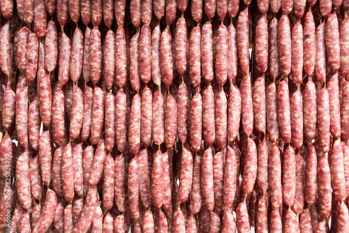 Close-up of ungrilled Taiwanese sausage bunches hanging on wooden sticks. This is one of the street snacks popular among tourists in Taiwan.