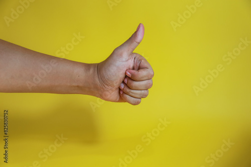 hand with thumb up isolated on yellow background with copy space, concept Admiration, Excellen photo