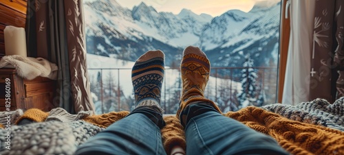A couple in love in knitted warm socks lies in a soft cozy bedroom overlooking the snow-capped mountains in winter. only legs. 