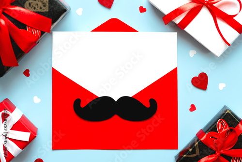 Happy Father's Day. Top view of red envelope with mustache and letter with copy space for text, hearts and gift boxes. Father's day concept