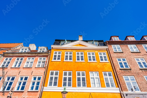 Colorful facades of old houses along Nyhavn embankment in Copenhagen - upward view. Denmark