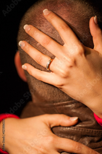 Closeup of an intimate embrace with a hand wearing a ring symbolizes closeness and affection in a relationship