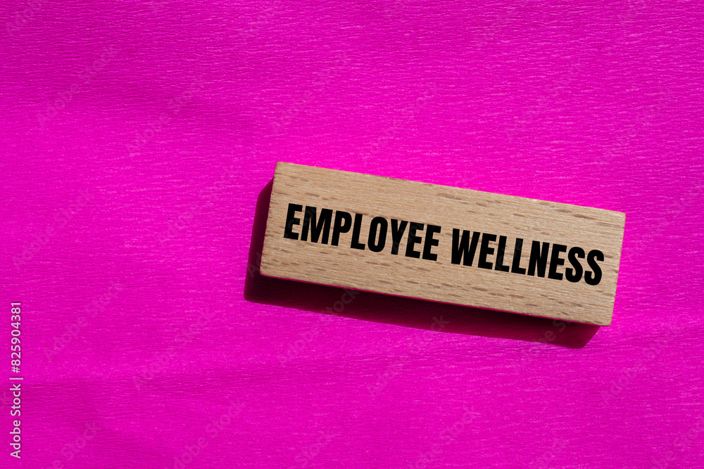 Employee wellness words written on wooden block with pink background. Conceptual employee wellness symbol.