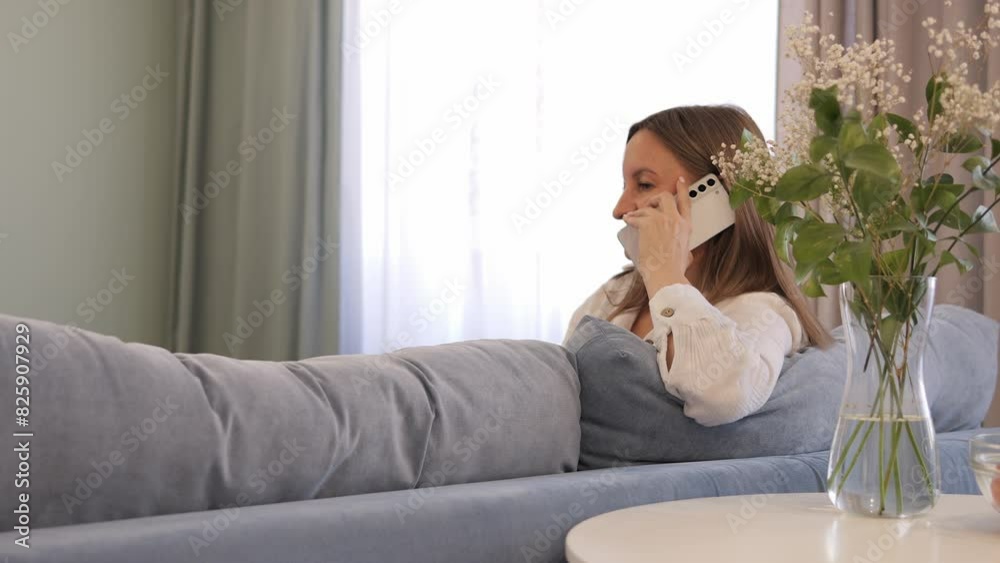 Woman is talking on phone while sitting on sofa A casual conversation that highlights moments of everyday life Ideal for telephone communication topics Telephone conversations are recorded naturally Woman is talking on phone while sitting on sofa A casual conversation that highlights moments of everyday life Ideal for telephone communication topics Telephone conversations are recorded naturally