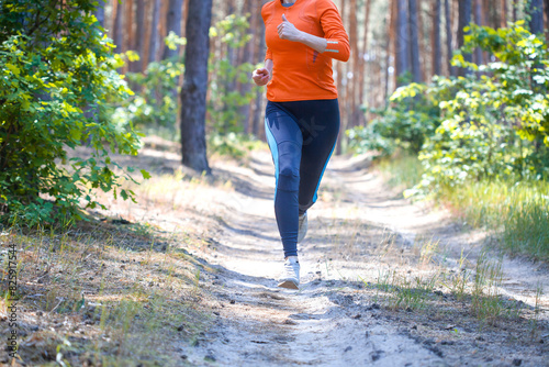 women athlete running through the woods.