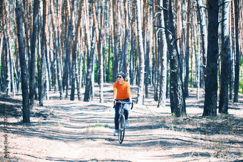 woman cyclist rides in the forest on a bike.