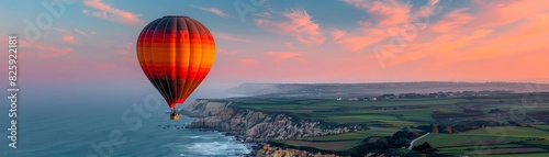 Stunning hot air balloon flight over scenic coastal landscape at sunset with dramatic skies and oceanic views. © Samon