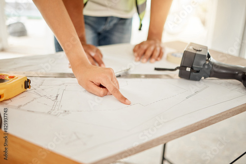 Architecture, hands and planning with blueprint on table for creativity, building design and pointing on paper. Architects, contractor or teamwork in floor plan, ideas or renovation project in office