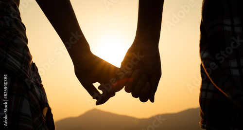 Friendship, Love and Valentine day concept. A couple holding hand during sunset, a symbol of love and happy relationship.