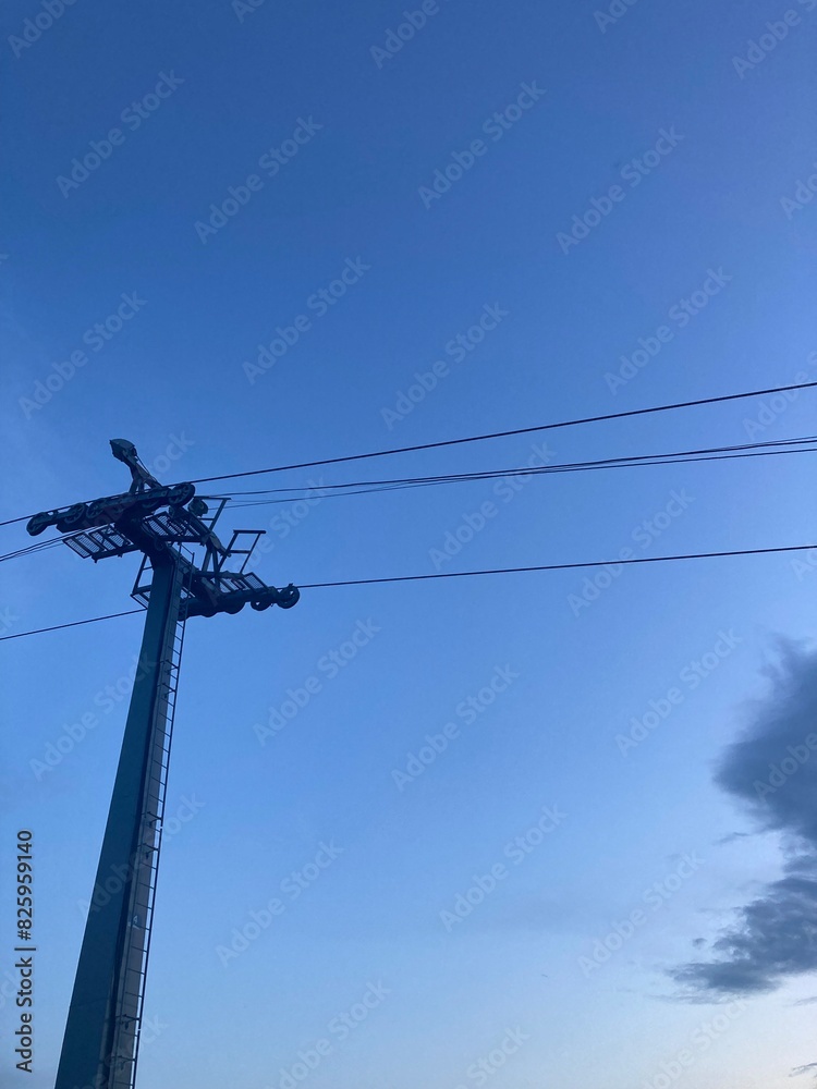 Ski lift against the backdrop of an ultramarine evening sky. Cable car pole with free space for advertising text. Ideal for creating banners or creatives for social networks, cover or flyer. Ski lift against the backdrop of an ultramarine evening sky. Cable car pole with free space for advertising text. Ideal for creating banners or creatives for social networks, cover or flyer.