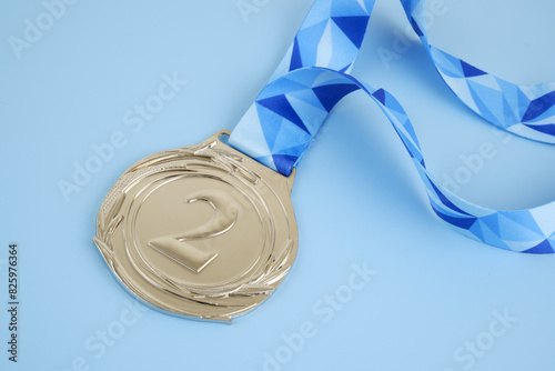 Silver medal with blue ribbon on blue background.