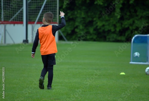 Boy in an orange T -shirt on a football field © lisica1