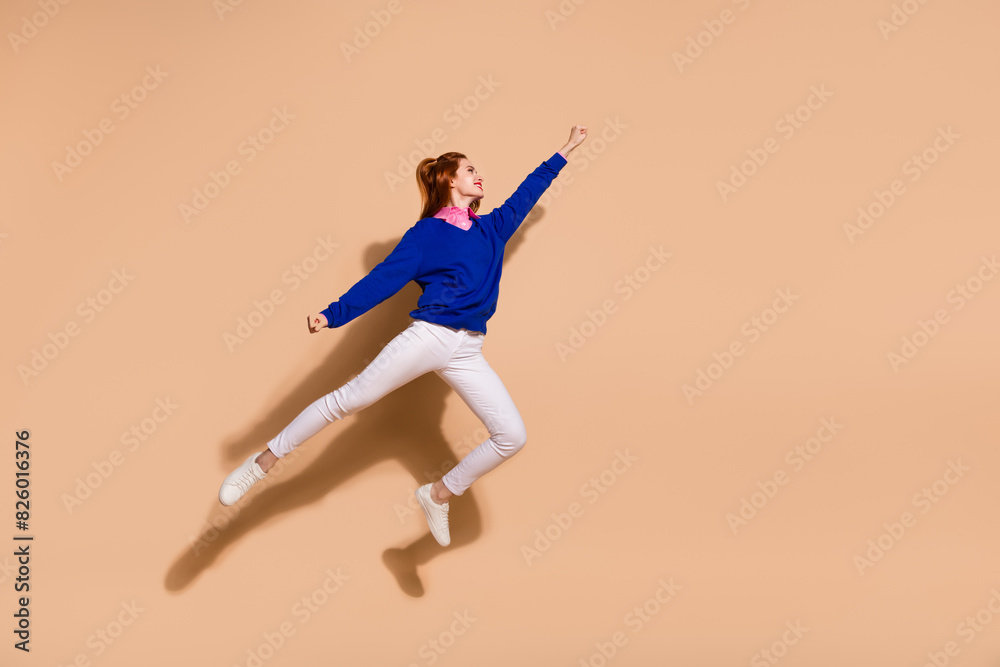 Full length portrait of pretty young lady jump fly empty space wear sweater isolated on beige color background Full length portrait of pretty young lady jump fly empty space wear sweater isolated on beige color background