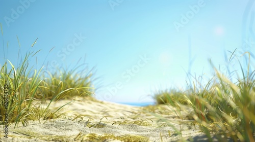 View from the base of a sand hill under a clear sky with tall grass photo