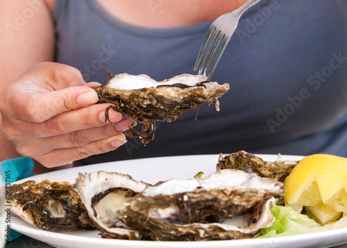 Woman eat with a fork oysters. Lifestyle concept