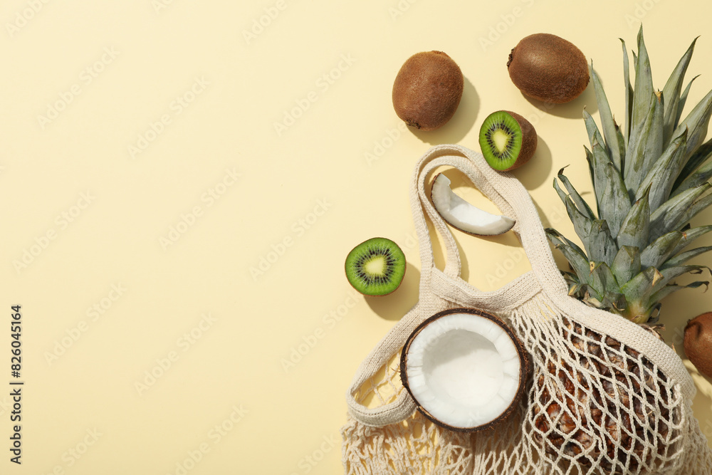 Set of tropical fruit in bag on beige background, space for text Set of tropical fruit in bag on beige background, space for text