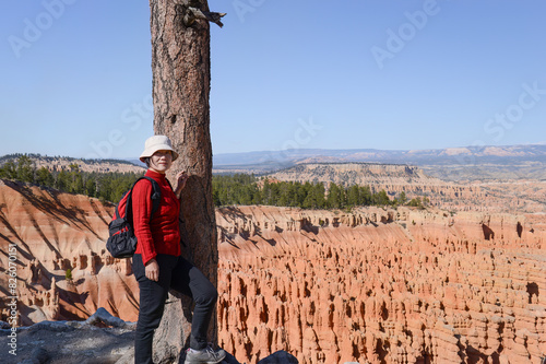 A female tourist posing for photos at Bryce Canyon Rim Trail. Utah. USA.