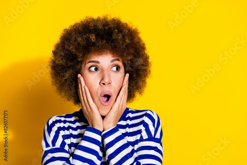 Photo of nice young girl stare empty space wear striped shirt isolated on yellow color background