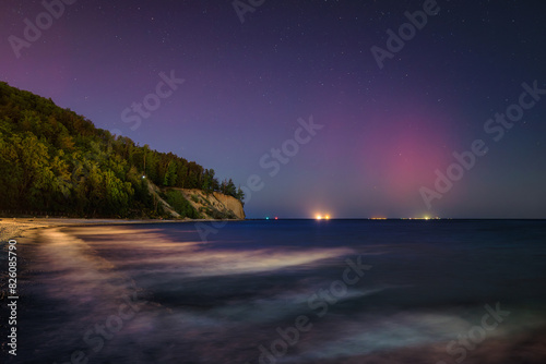 Baltic cliff in Gdynia Orlowo at night with Northerm lights over the sea. Poland