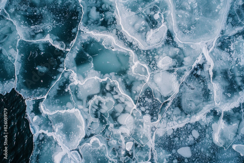 Aerial view of ice floes in a frozen sea, capturing the abstract patterns and textures formed by the ice. Emphasize the natural lines and the contrast between the white ice and the dark water. photo