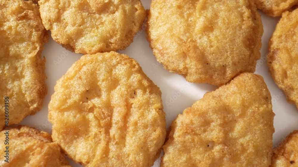 A chicken nugget is a small, breaded and fried piece of chicken meat, often served as a fast food snack or meal accompaniment. Shot with 24mm probe macro lens. Food background. 
