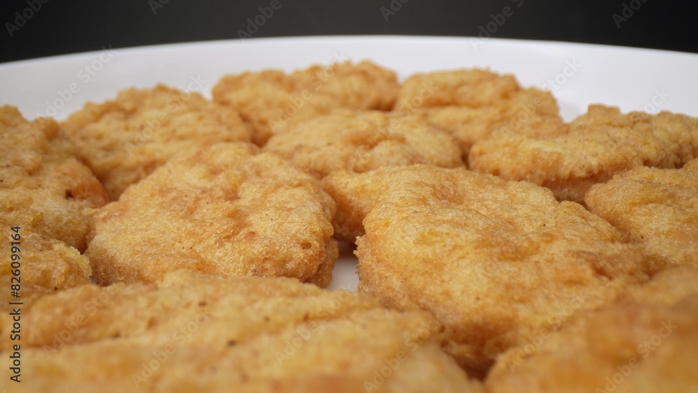 Chicken nuggets are small, battered, and deep-fried pieces of chicken, often served as a fast-food snack or a kid-friendly meal, known for their crispy exterior and tender interior. Food concept.
Chicken nuggets are small, battered, and deep-fried pieces of chicken, often served as a fast-food snack or a kid-friendly meal, known for their crispy exterior and tender interior. Food concept.