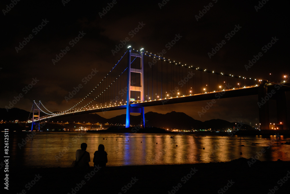 Fototapeta premium Two people under the Tsing-Ma Bridge at night