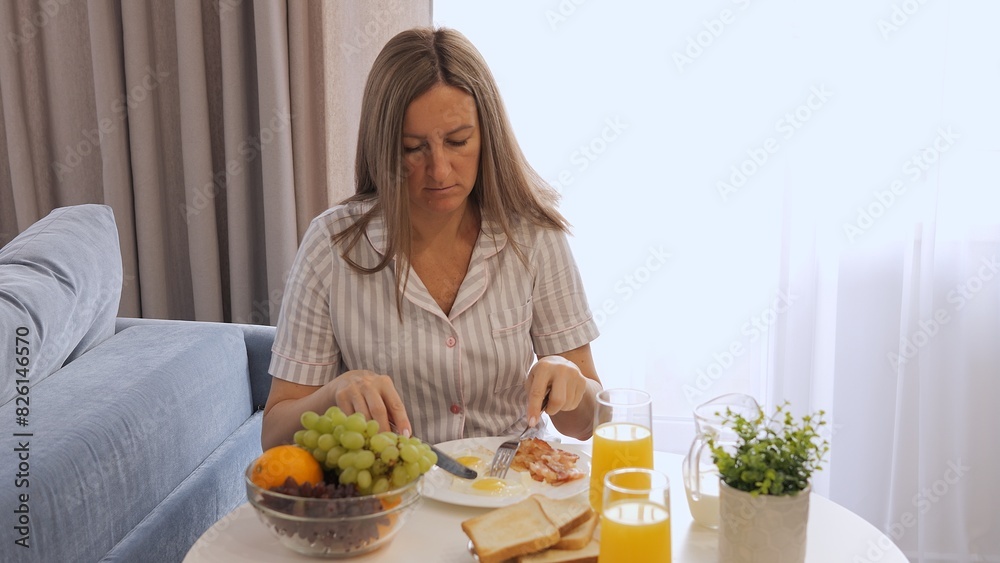 Woman enjoying breakfast with scrambled eggs. Morning routine with delicious and healthy scrambled eggs. Ideal for food, breakfast theme. Scrambled eggs will be a nutritious start to her day.