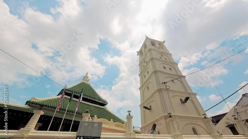Melaka, Malaysia - 10th april, 2024: panning view Kampung Kling Mosque. Minaret and mosque facade in sunny blue sky day. photo
