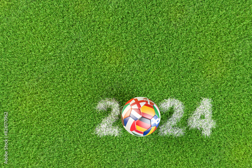 Soccer ball with the flags of several European Countries playing in Germany in 2024. The year 2024 displayed as chalk marking in the grass.