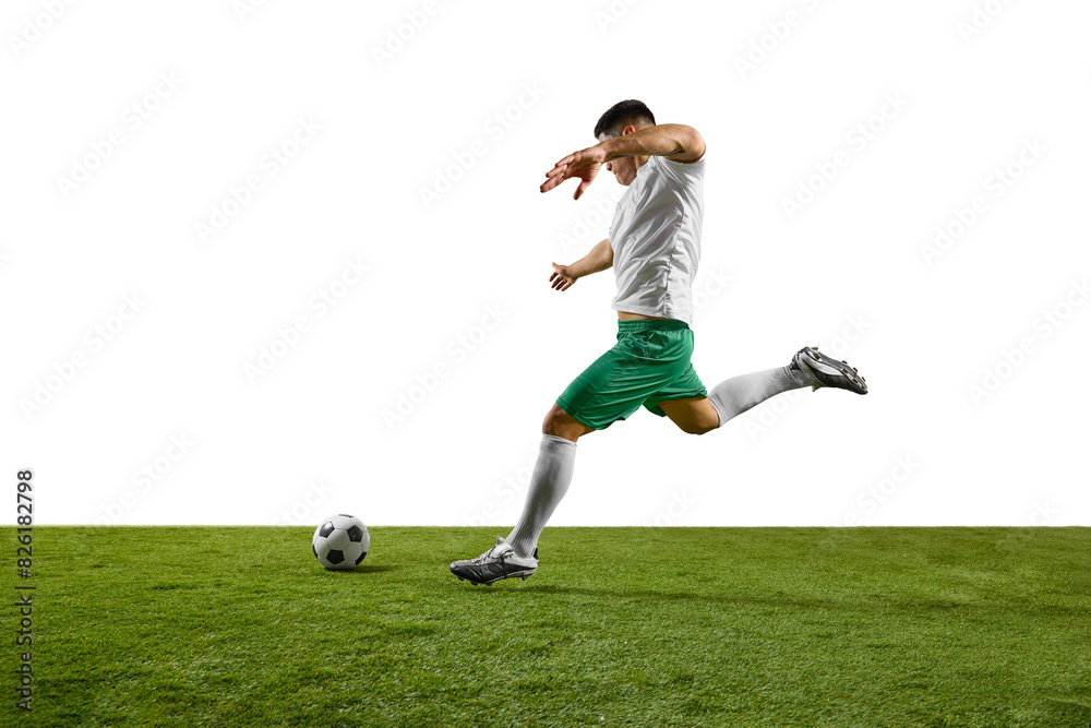 Dynamic image of young footballer prepares to strike soccer ball on lush green pitch against white studio background. Concept of professionals sport, competition, tournament, energy, action. Ad