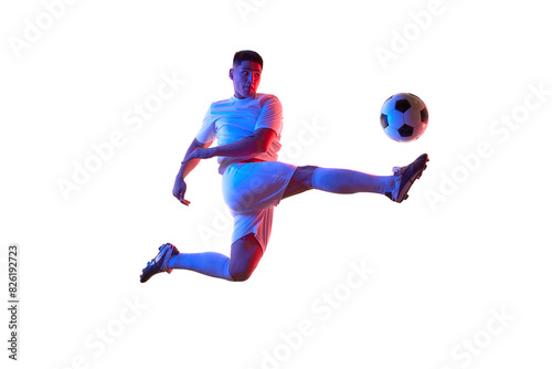 Dynamic portrait of young man, professional soccer player make perfect pass in mid-air in neon light against white studio background. Concept of professionals sport, competition, tournament, action. © Lustre