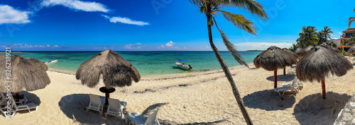 White sand beach with palapa to protect yourself and enjoy the Caribbean sun on summer vacation, and the crystal clear turquoise water typical of the Riviera Maya in Mexico.