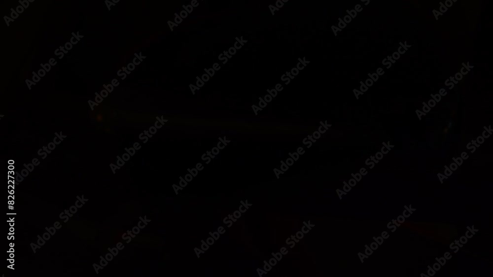 Blinking tail light of a car in orange colour in closeup  on a black background. Optical looking rear car lights blinking on black.