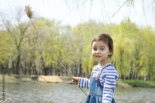Little adorable smiling girl in spring outdoors.