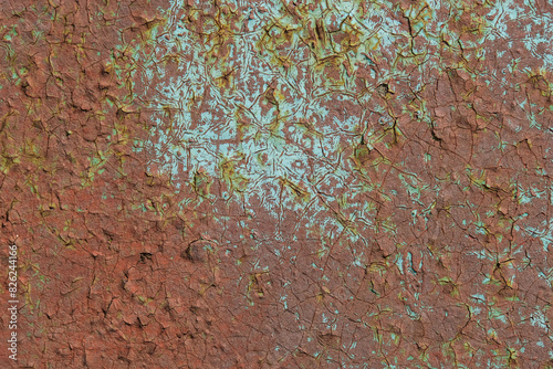Detailed view of a rusty, cracked metal surface with peeling paint, showcasing textures and patterns of corrosion.