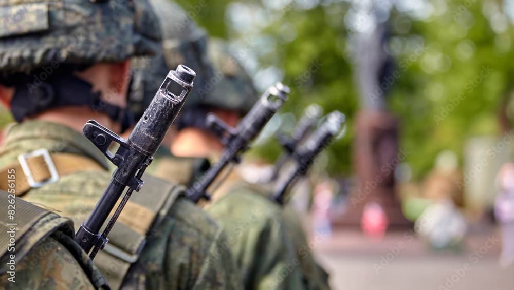 Brave soldier in camouflage uniform standing at attention with rifle on shoulder Brave soldier in camouflage uniform standing at attention with rifle on shoulder