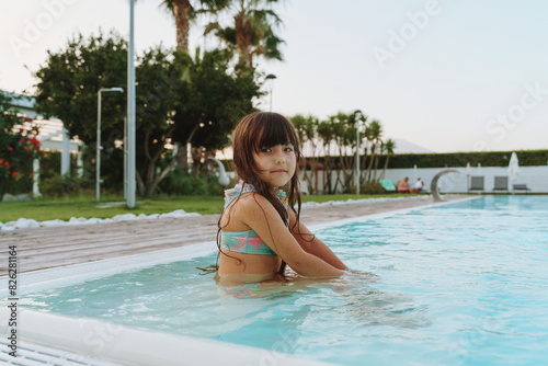 girl in outdoor swimming pool on summer vacation