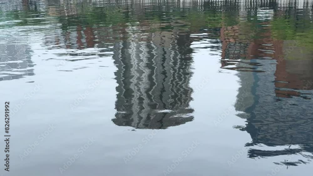 Rippling reflections of urban buildings on calm water on a clear day Rippling reflections of urban buildings on calm water on a clear day