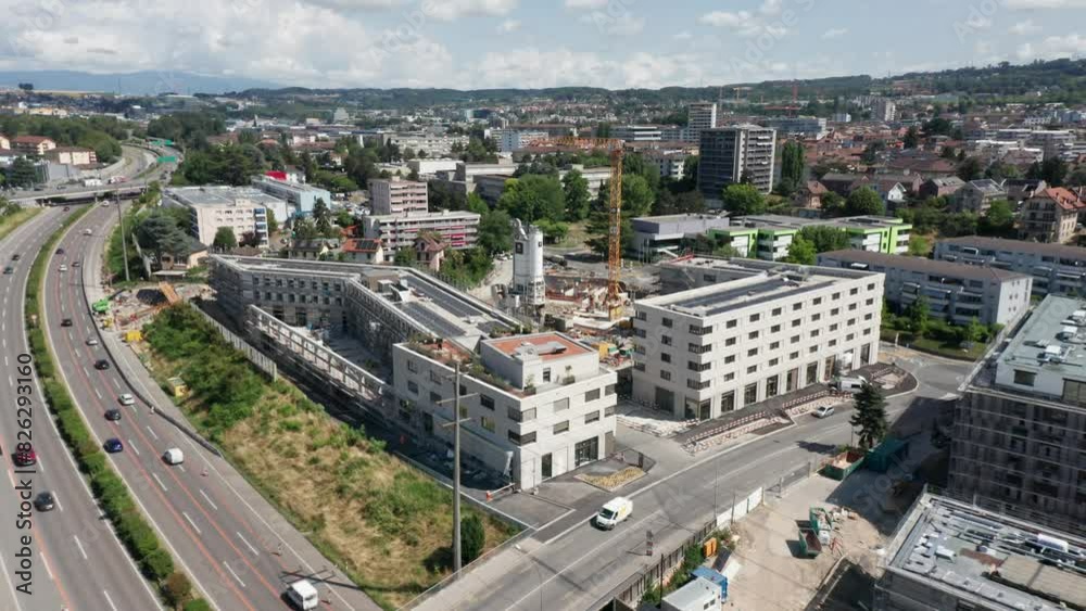 Drone slowly flying away from construction site with newly built structures and revealing the skyline of a beautiful city in Switzerland Drone slowly flying away from construction site with newly built structures and revealing the skyline of a beautiful city in Switzerland
